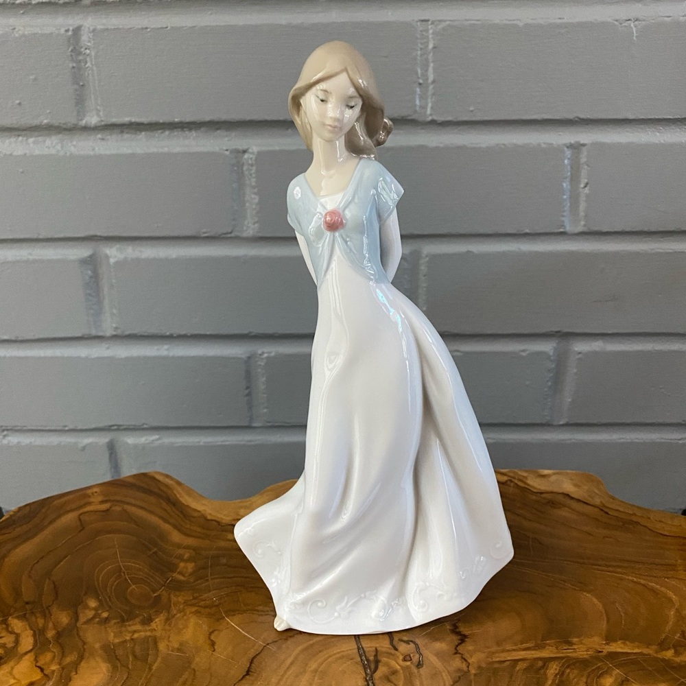NAO hand made porcelain by lladro girl with slippers behind her back